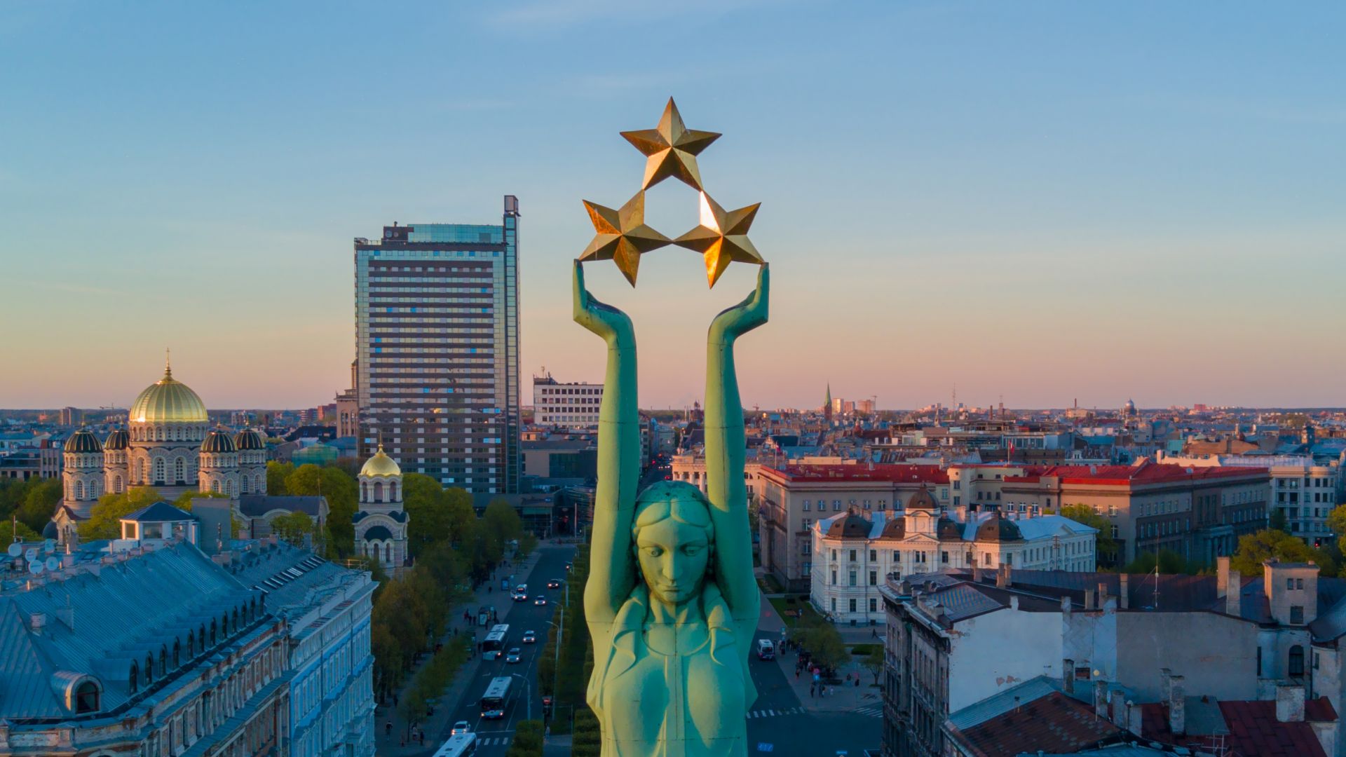 Splendide coucher de soleil à Riga aux alentours de la statue de la Liberté - Milda. La Liberté en Lettonie. Statue de la Liberté tenant trois étoiles au-dessus de la ville.