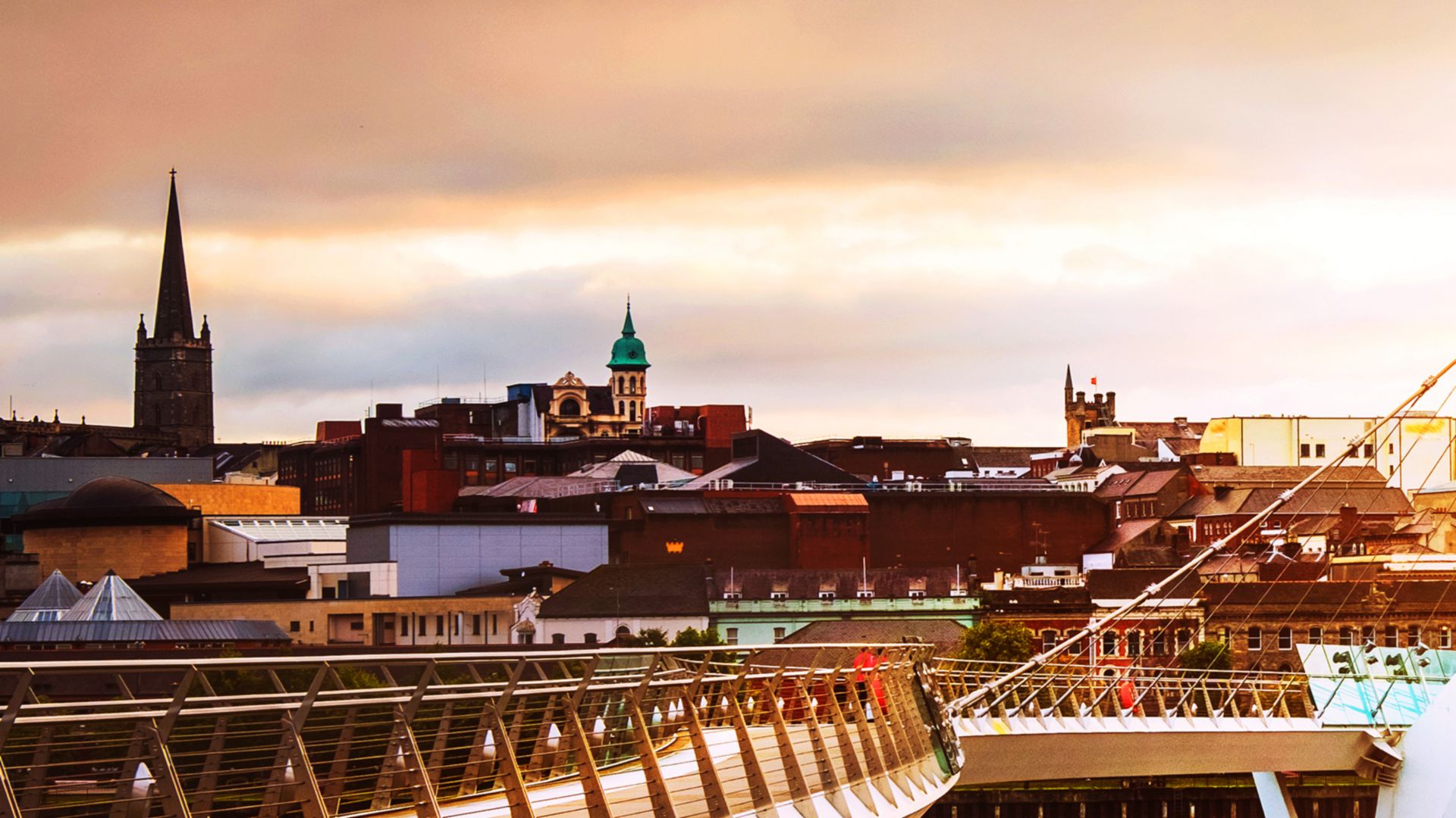 Derry~Londonderry, Nordirland. Beleuchtete Friedensbrücke mit Stadtzentrum im Hintergrund.