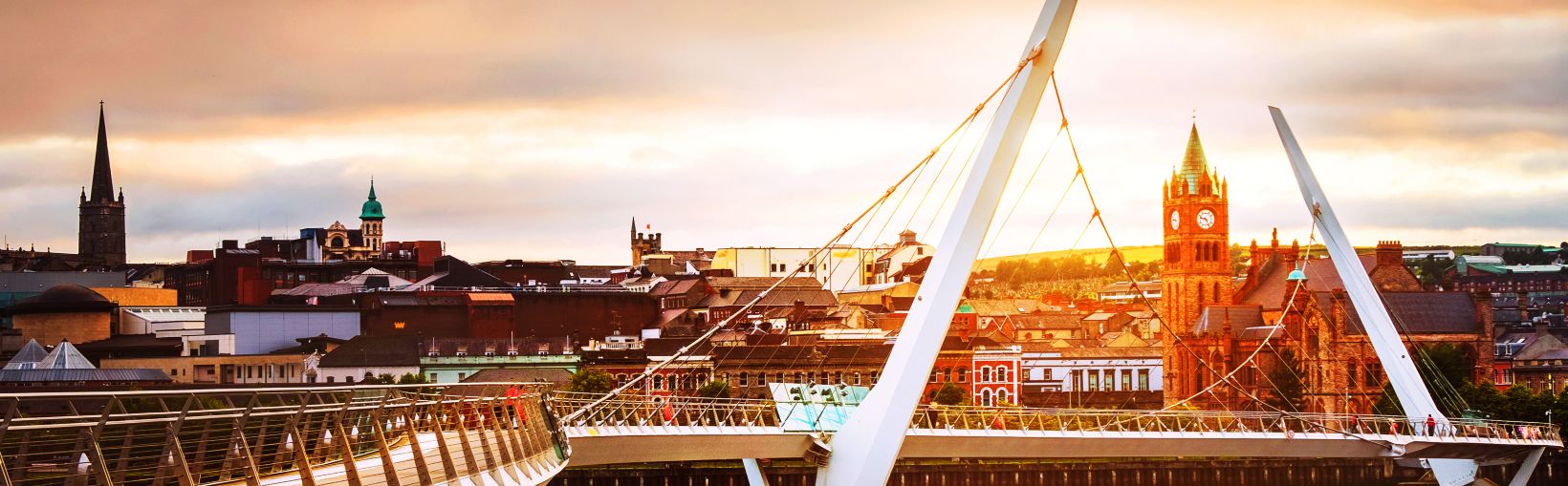 Derry~Londresderry, Irlande du Nord. Pont de la paix illuminé avec le centre-ville en arrière-plan.