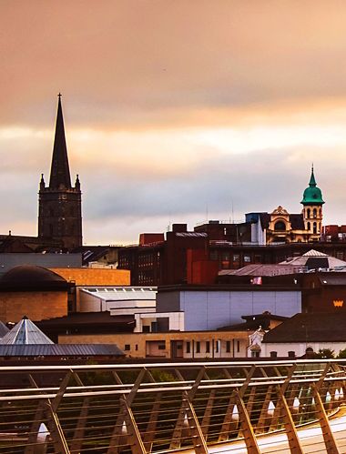 Derry ~ Londonderry, Pohjois-Irlanti. Valaistu rauhansilta, jonka taustalla on kaupungin keskusta.