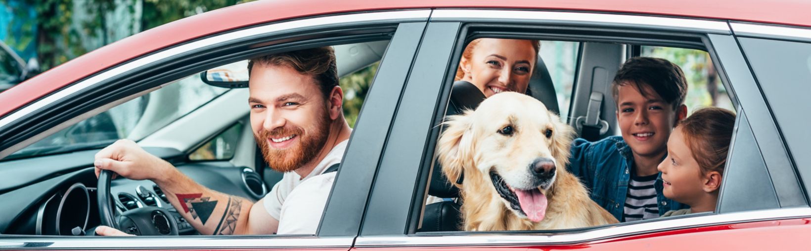 A car filled with a family and a dog