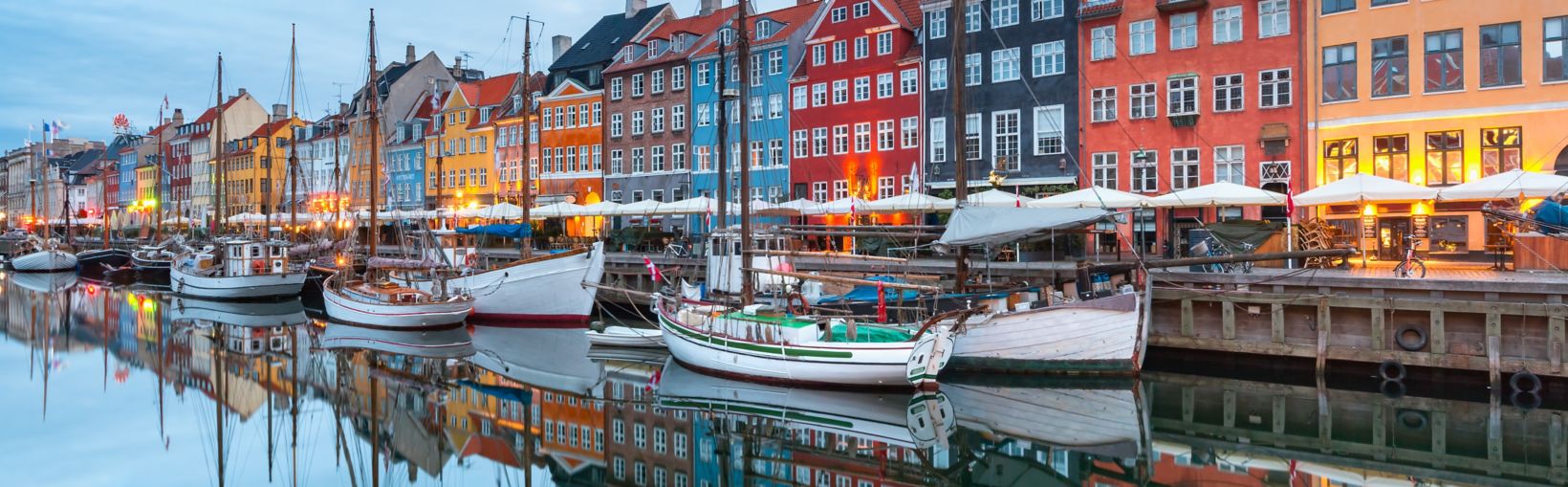 Nyhavn with colorful facades of old houses and old ships in the Old Town of Copenhagen, capital of Denmark.
