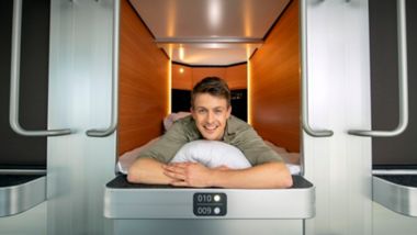 Ein Mann lächelt, während er sich in einer Schlafkoje an Bord einer Stena Line Fähre entspannt
