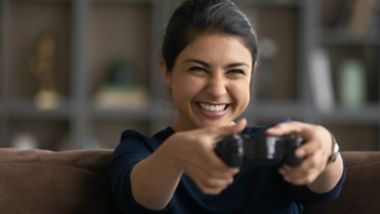 Ülirõõmus teismeline lõbutsemas ja kodus mängupuldiga videomänge mängimas. Naeratav noor naismängija lõdvestumas, osaledes nädalavahetusel virtuaalse digitaalreaalsuse üritusel. Hobi, videomängu kontseptsioon.