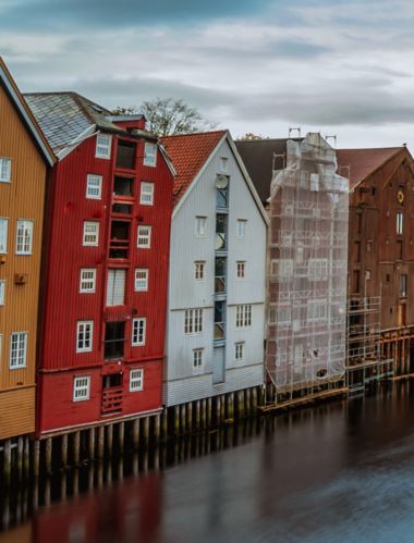 Panorama af farverige bygninger langs kanalen i Trondheim