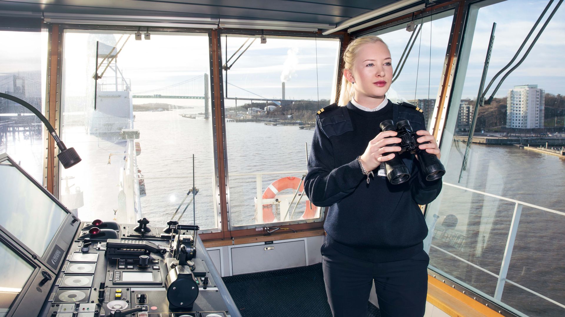Young female officer with binoculars on the bridge of a Stena Line ferry