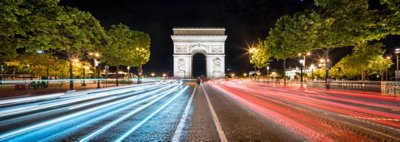 Arc de Triompe in Paris, France at night with light trails from vehicles