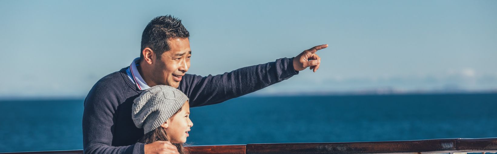 Père faisant sauter le repère sur un court-circuit à la fille alors qu’il se tient sur le pont extérieur d’un ferry