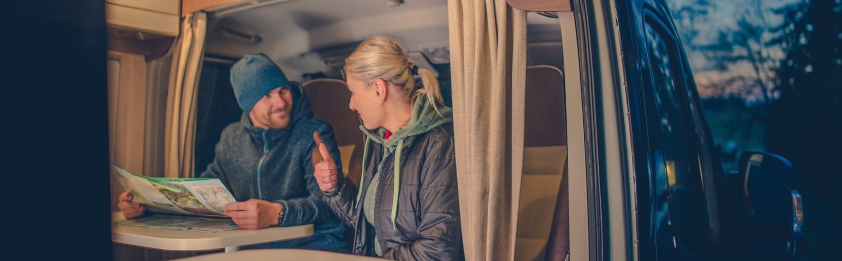 Couples and the RV Park Camping. Young Couples Planning Next Trip in the Motorhome.