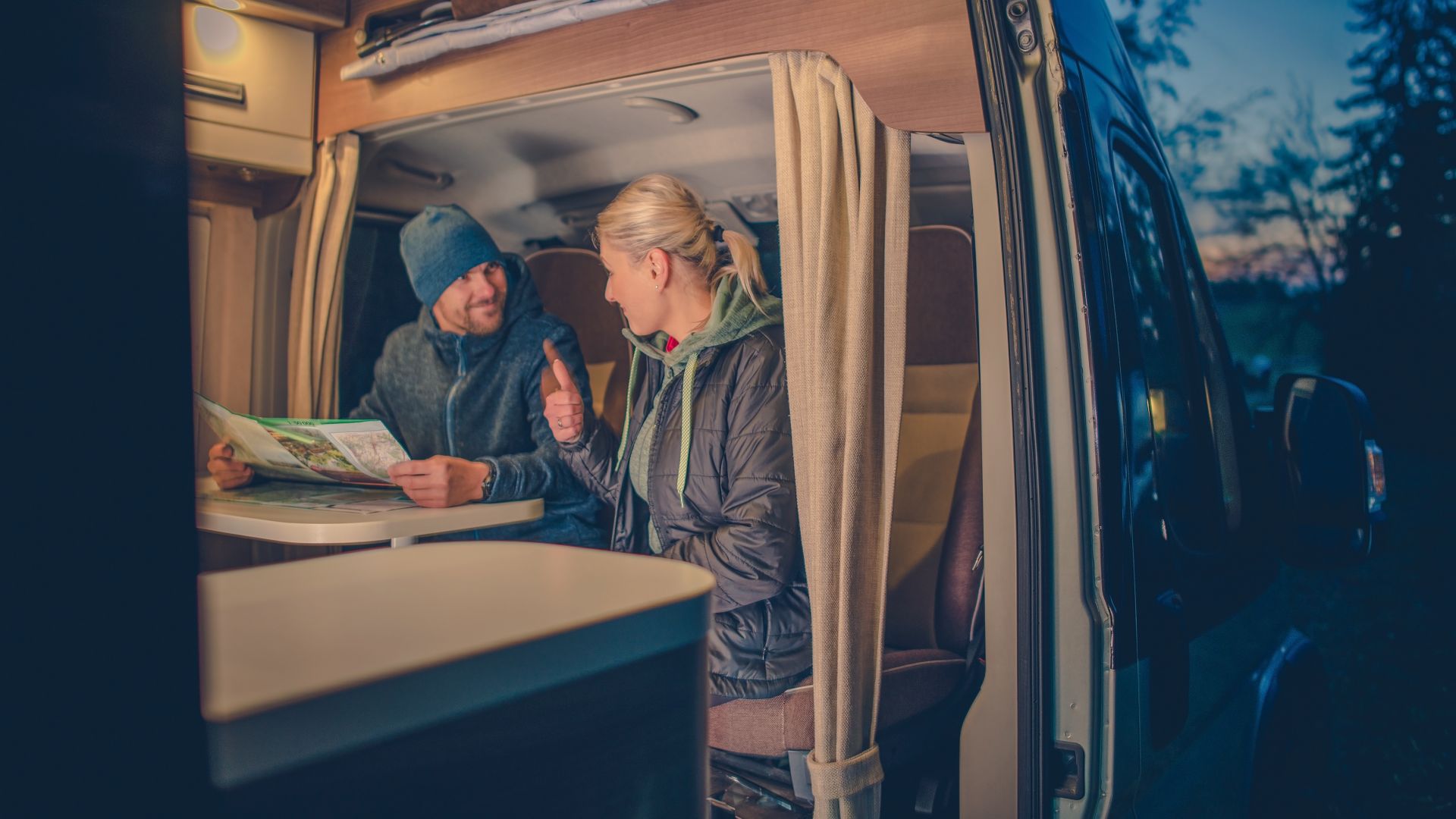 Couples and the RV Park Camping. Young Couples Planning Next Trip in the Motorhome.