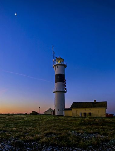 Fyrtårn på kysten av Sverige ved solnedgang