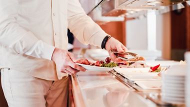 Man serving himself in the Buffet Restaurant onboard