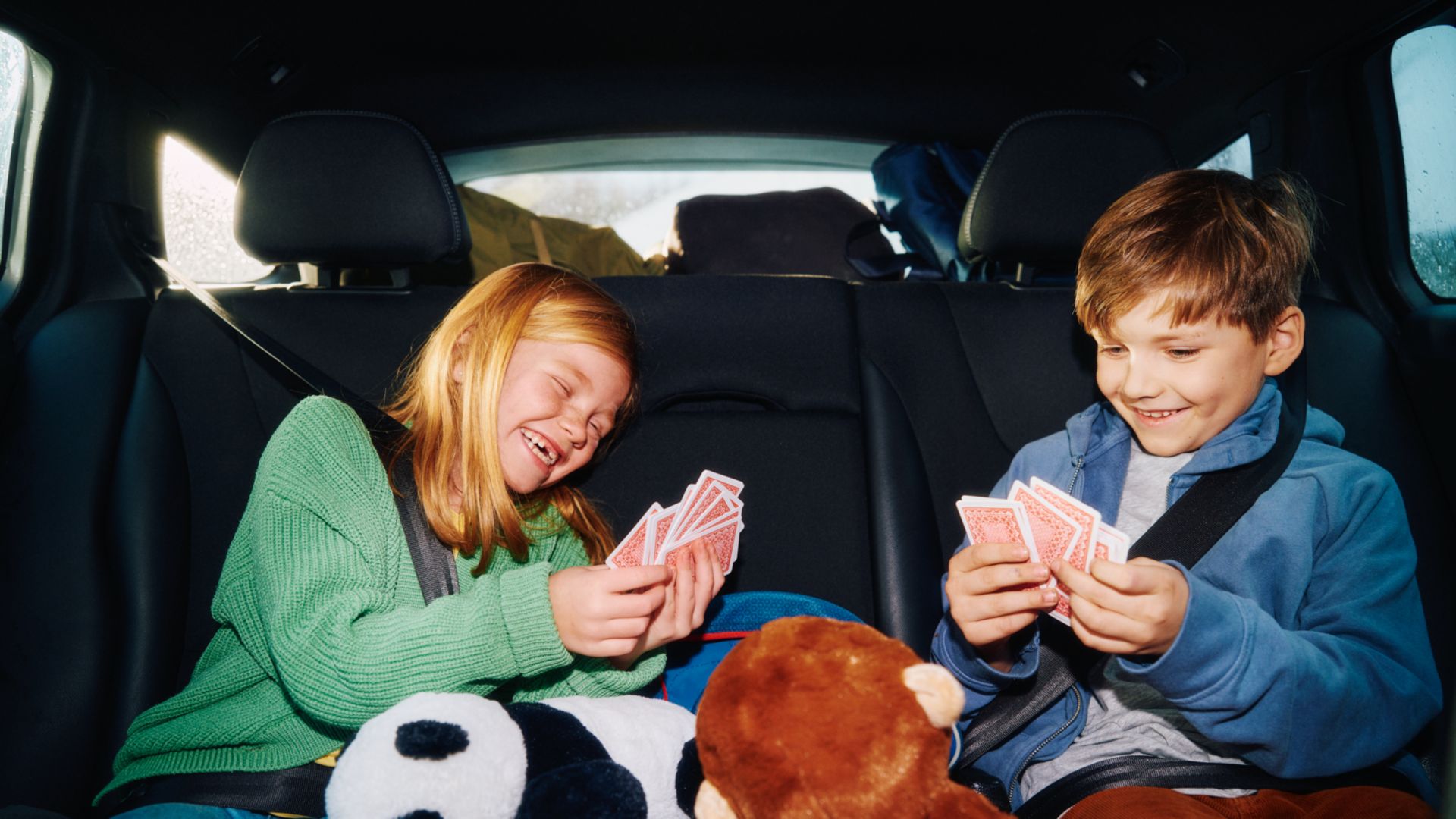 Kids in car playing cards