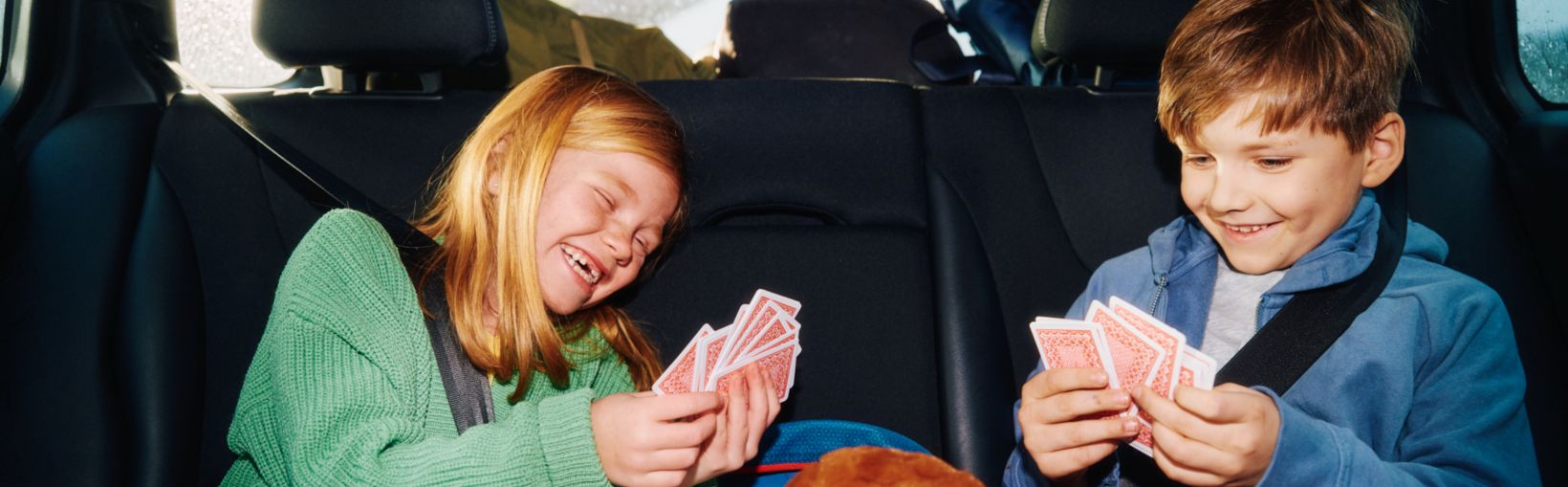 Kids in car playing cards