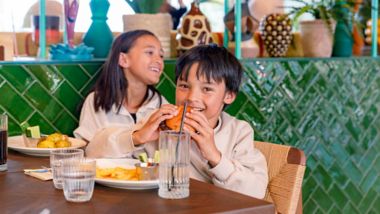 Två glada barn njuter av maten på restaurangen på Quality Hotel The Reef i Frederikshavn