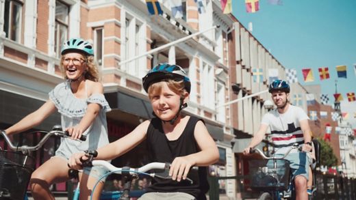 Rodzina jedzie rowerami ulicami Karlskrony w słoneczny dzień plus relaksująca miejska podróż promem