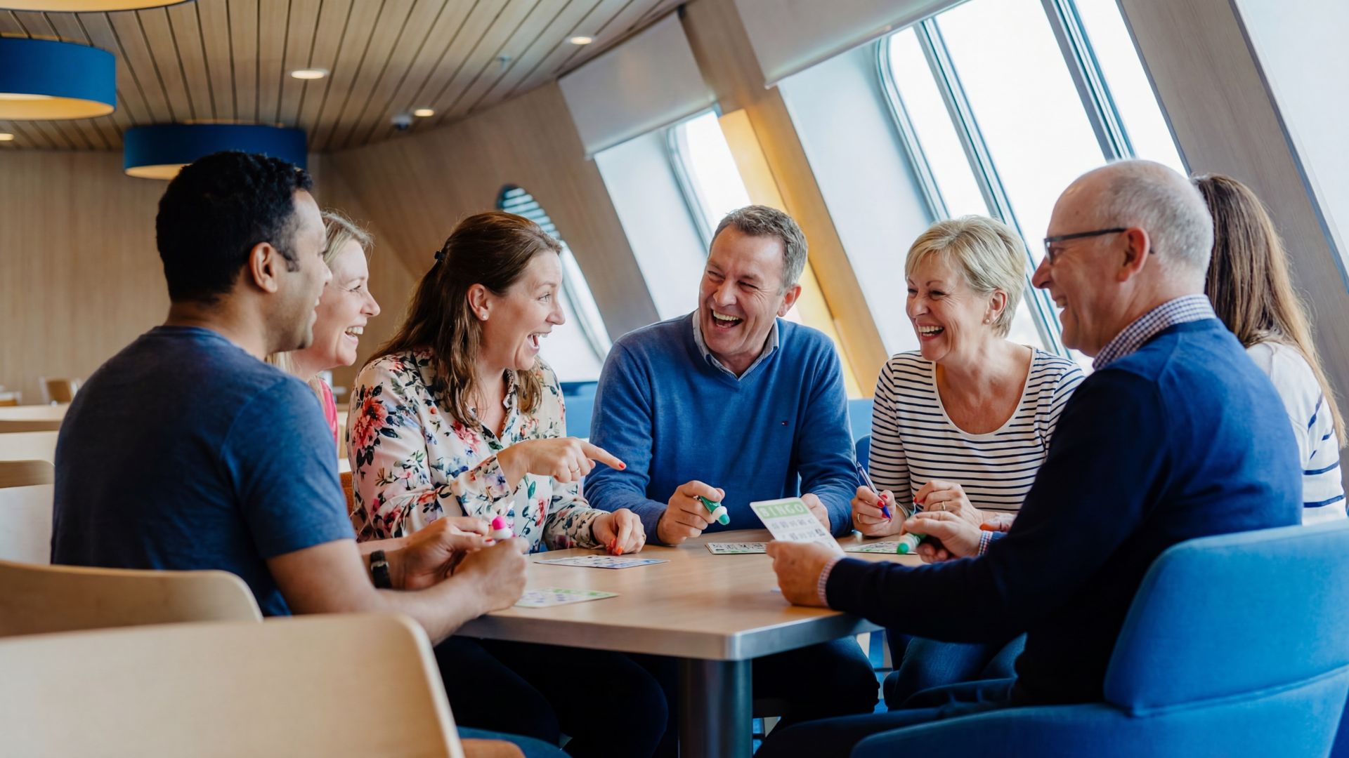 Friends enjoying a lively bingo game onboard a Stena Line ferry, creating a fun and social travel experience
