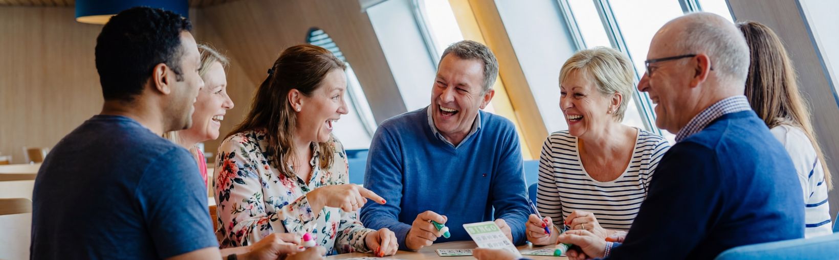 Friends enjoying a lively bingo game onboard a Stena Line ferry, creating a fun and social travel experience