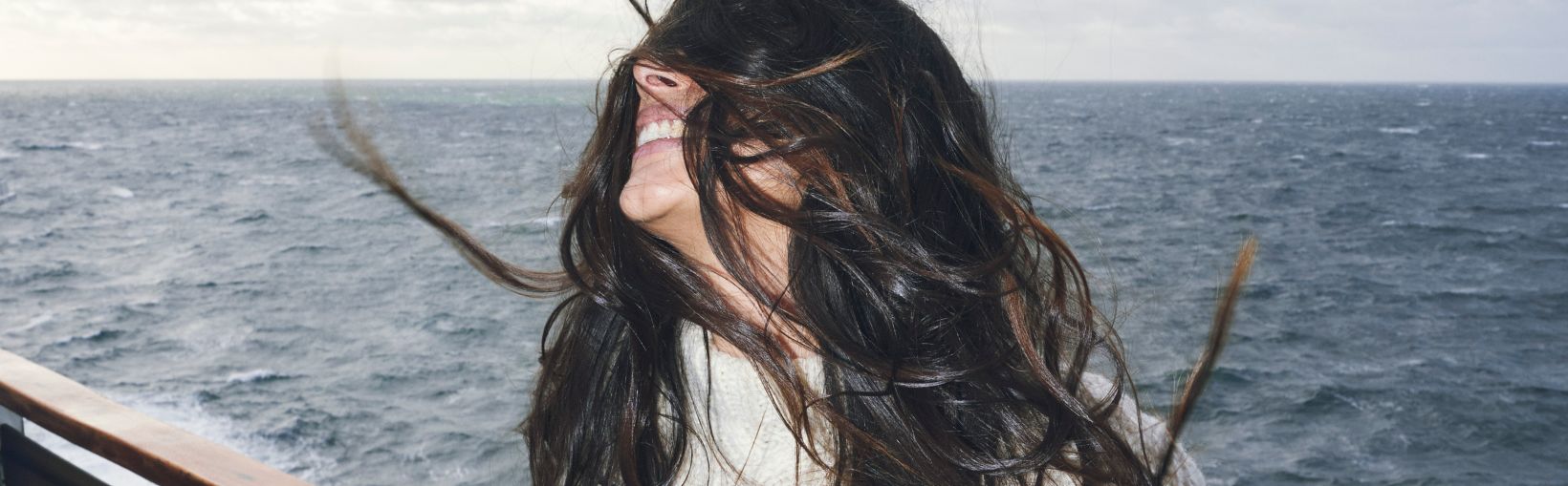 Solo woman on deck, wind on her face