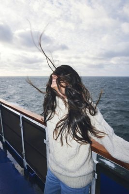 Solo woman on deck, wind on her face