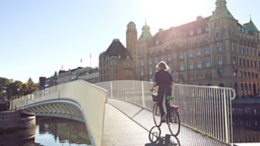 Woman biking over bridge