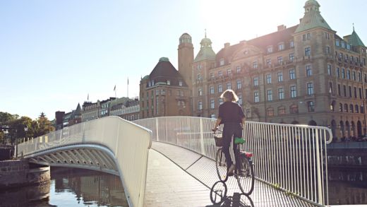 Woman biking over bridge