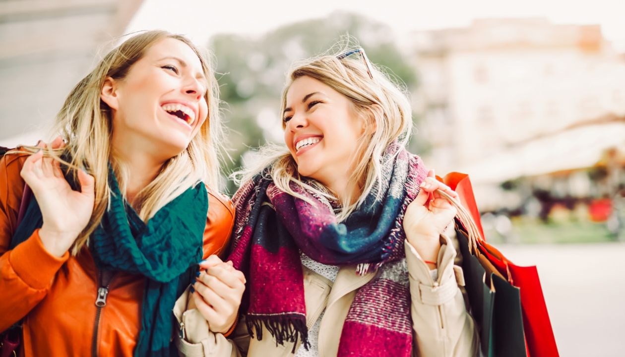 Happy friends shopping. Two beautiful young women enjoying shopping in the city.