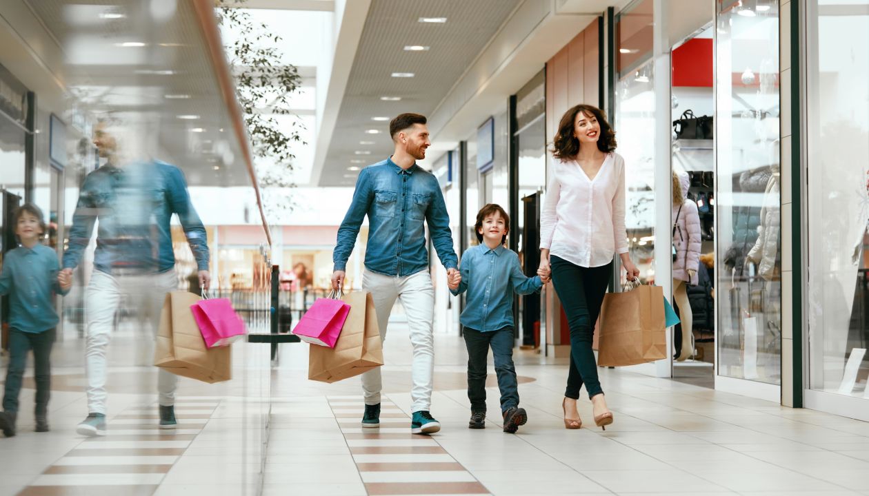 Family Shopping. Happy People With Child Carrying Bags, Walking In Modern Mall. High Resolution.