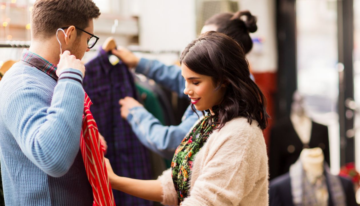 sale, shopping, fashion and people concept - couple choosing clothes at vintage clothing store