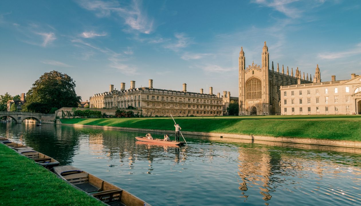 Beautiful view of college in Cambridge with people punting on river cam