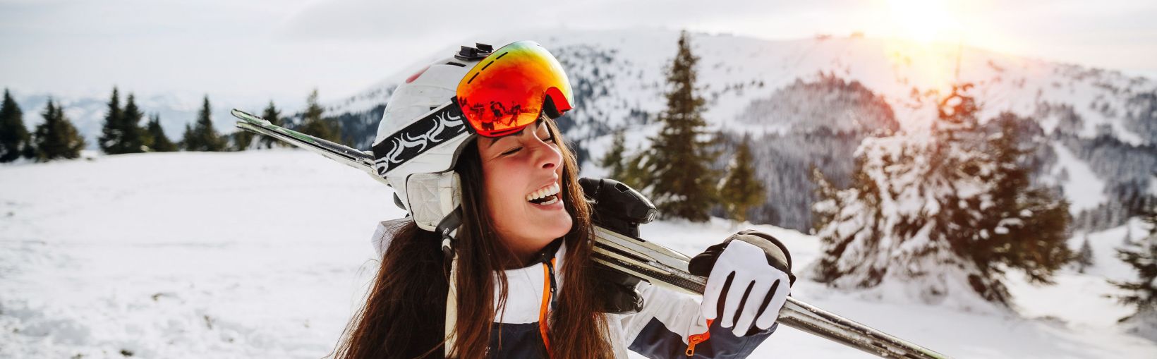 Portrait of beautiful woman with ski and ski suit in winter mountain