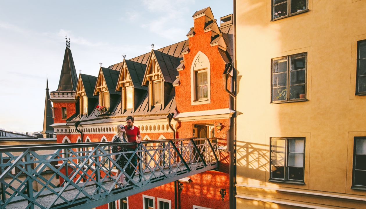 Hugging couple in love traveling together in Stockholm romantic vacations urban lifestyle architecture colorful houses european Sweden landmarks