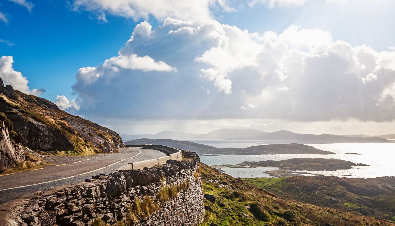 Landskap av bergsväg, kullar och Atlanten. Ring av Kerry, Irland. Resmål