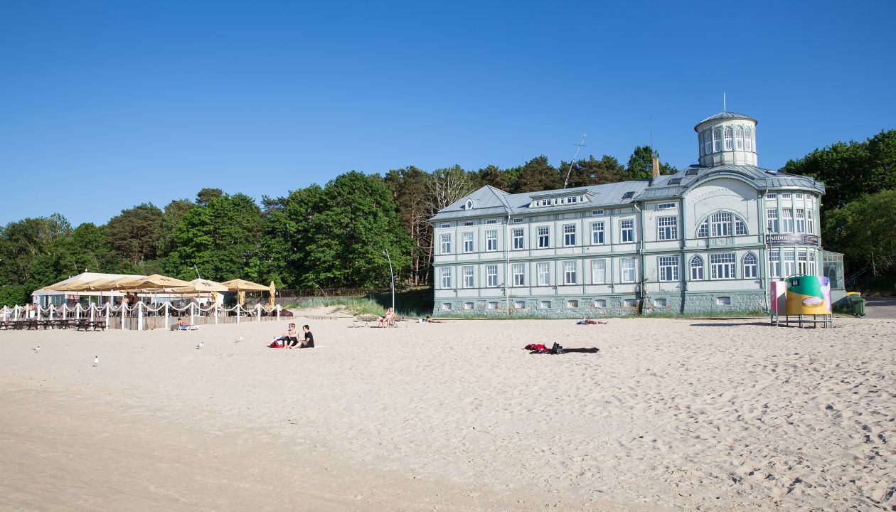 City Jurmala, Latvian Republic. Peoples walking on sand beach. Urban view with tourists and buildings.Travel photo. 2019. 4. Jun