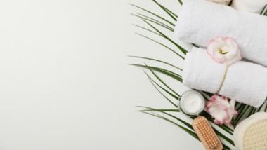 Spa accessories and palm branch on white background, copy space. Bodycare