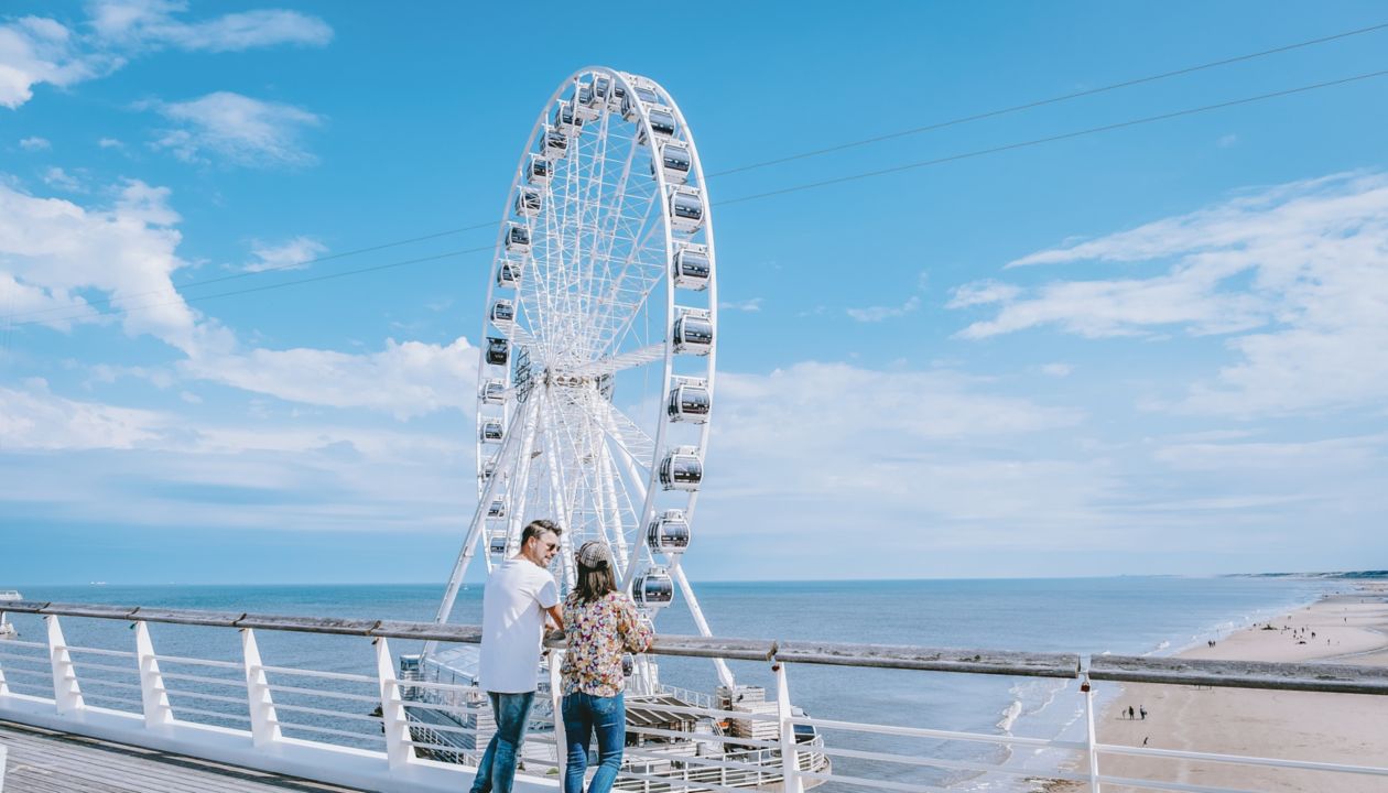  The Ferris Wheel The Pier at Scheveningen, The Hague, The Netherlands on a Spring day, couple man and woman mid age on the beach