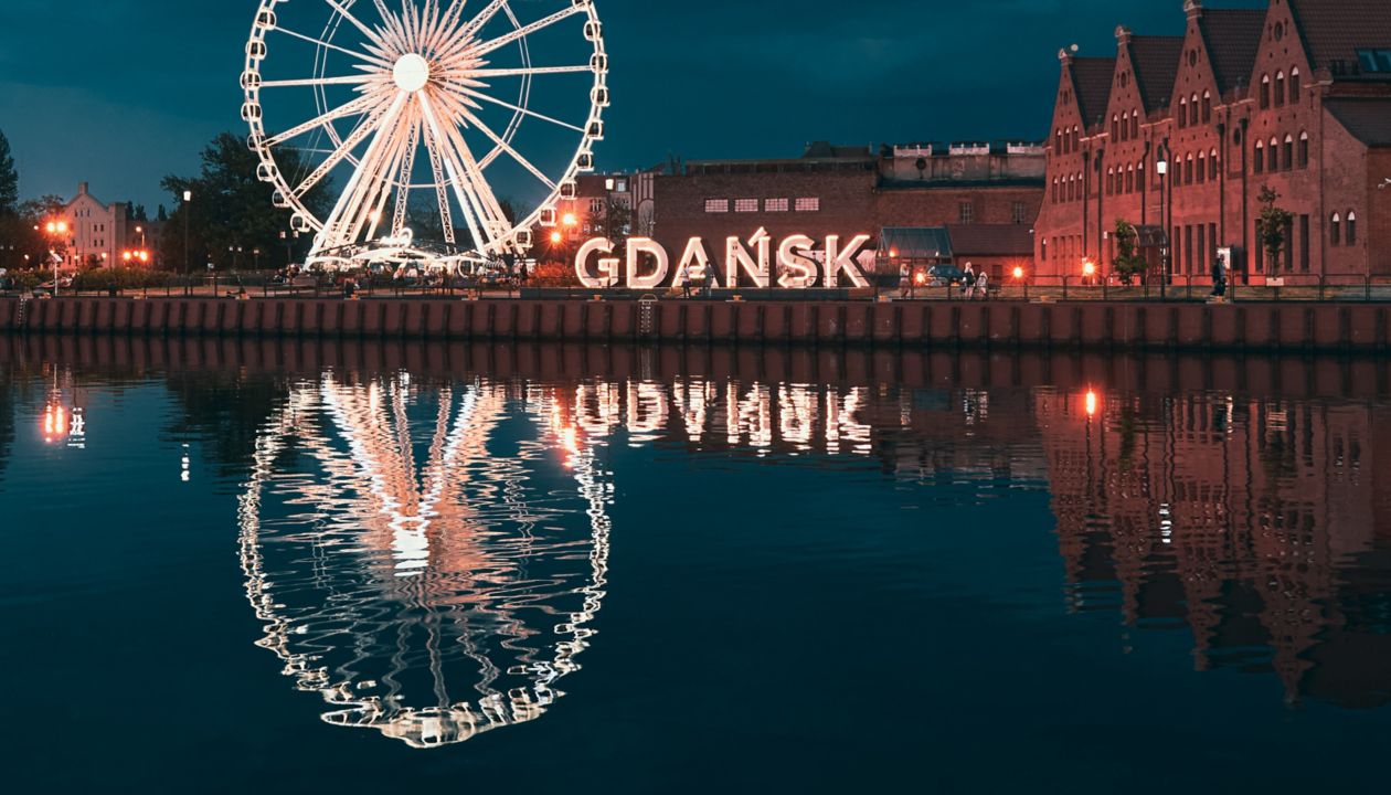 Reflection of the Ferris wheel in Gdansk, Poland. Old town center in the touristic city on the shore of the Baltic Sea in Poland. Beautiful night city lights