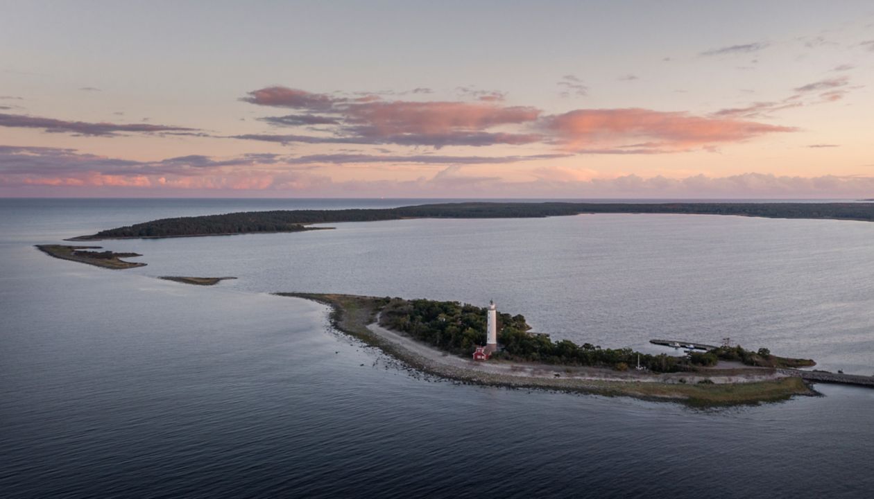 Coast and lighthouse Lange Erik on north coast of the island of Ã land in the east of Sweden from above during sunset
