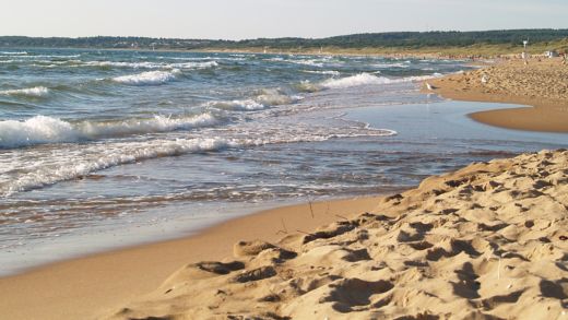Waves rolling onto a sandy Swedish beach, inviting coastal escape and Baltic Sea travel inspiration