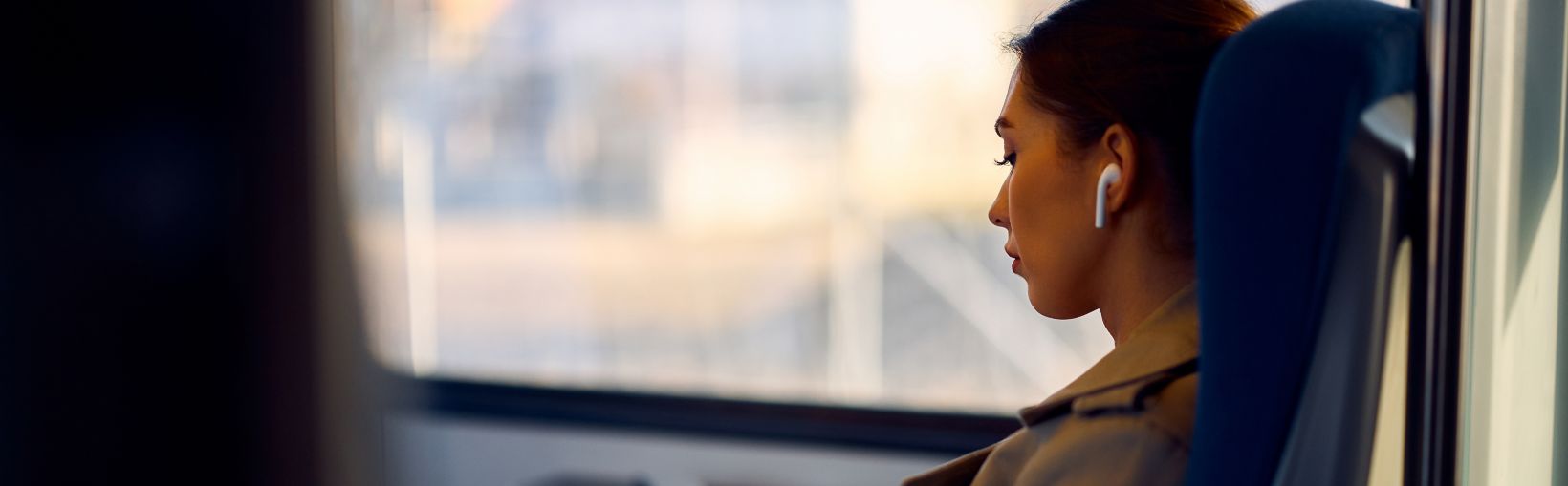 Young female passenger reads book while traveling by train.