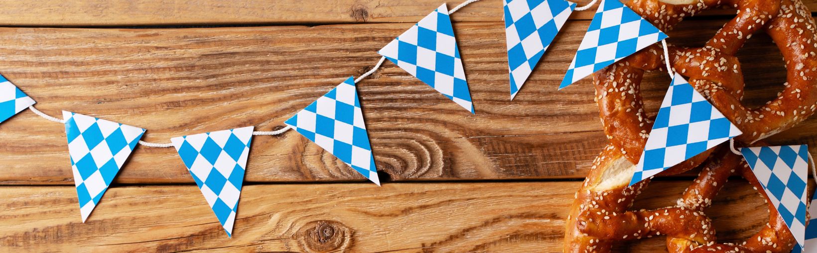 Oktoberfest koncept med kringla och blå simbol flagga på träbakgrund