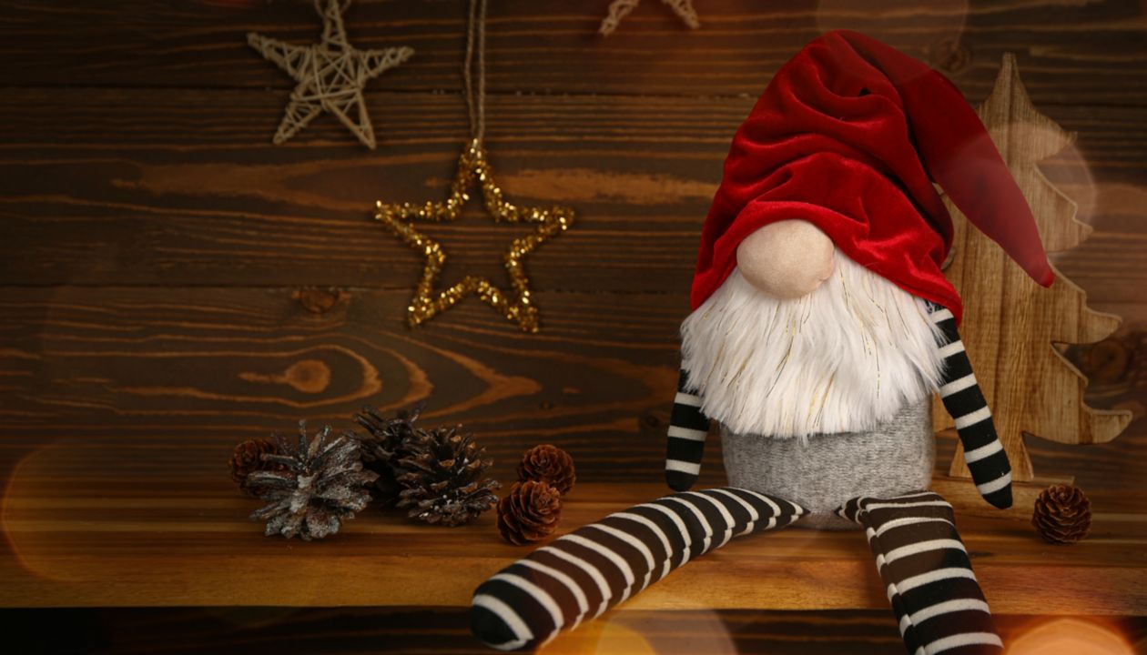 Christmas gnome with decorations on wooden background with space for text