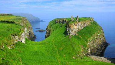 Ruins of the ancient Dunseverick Castle atop the green cliffs of the Causeway Coast, Northern Ireland