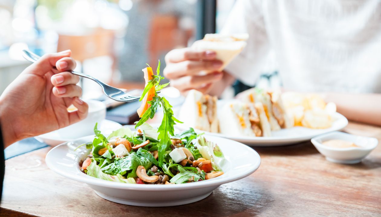 Twee mensen die een veganistische lunch eten