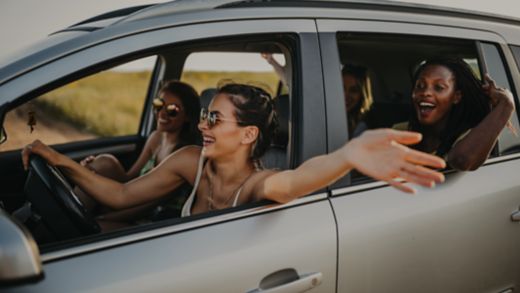 Four cheerful female friends having fun on  summer road trip