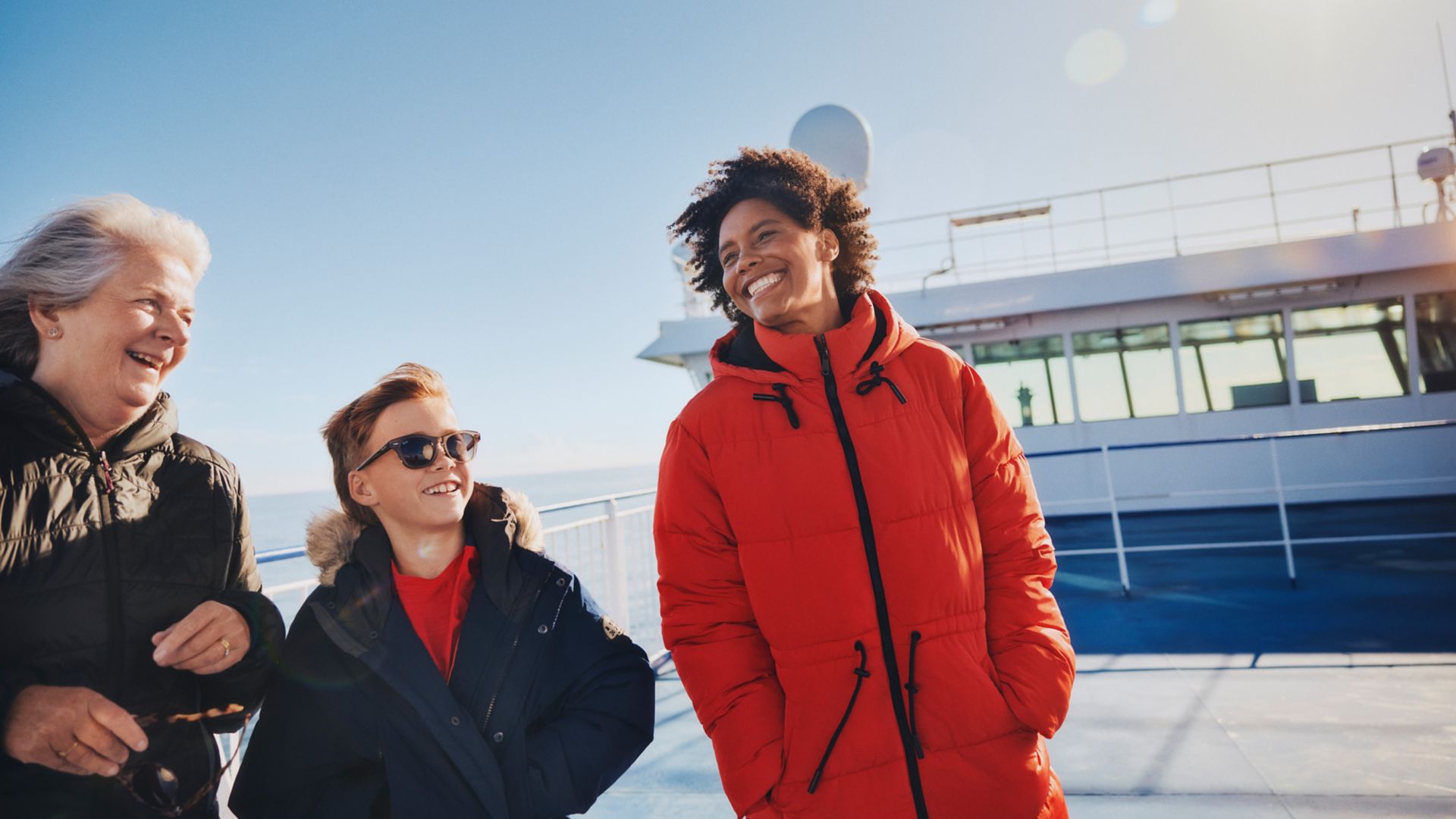 Smiling family enjoying fresh sea air on a sunny ferry deck crossing with Stena Line