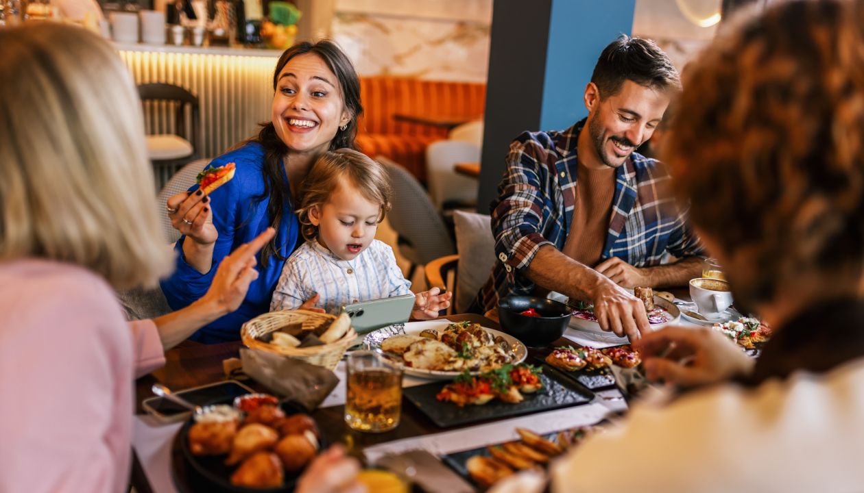 Family and friends gathered in a restaurant to eat delicious food, talk, drink and hang out.