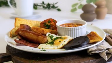 Full breakfast with sausages, bacon, fried eggs, beans, hash browns and toast