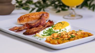 Salchicha y tocino con huevo frito y alubias al horno
