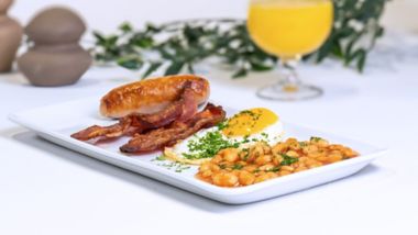 Sausage and bacon with fried egg and baked beans